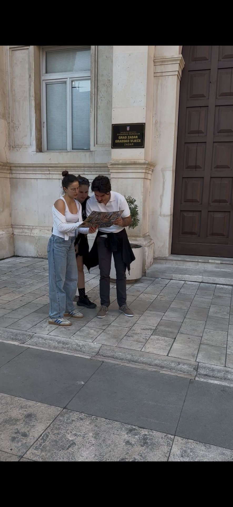 A team reading the photo-clue map in front of the Zadar city council