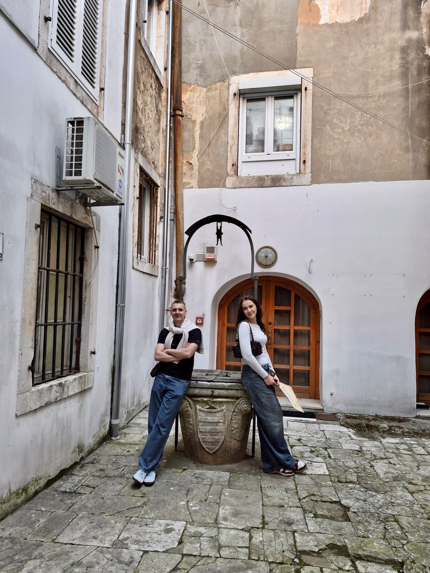 Team resting at a stone well in a hidden Zadar courtyard
